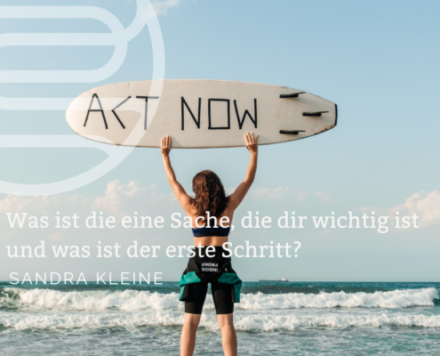 Titelbild zum Blog Vorsätze und Richtung_Frau mit Surfbrett zu sehen, auf dem ACT NOW zu lesen ist